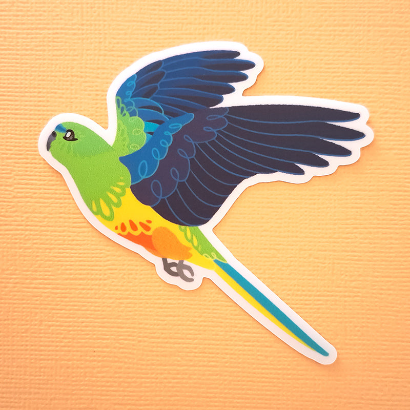 Real photo of a colourful sticker of an Orange-Bellied Parrot in flight on an orange canvas textured background.