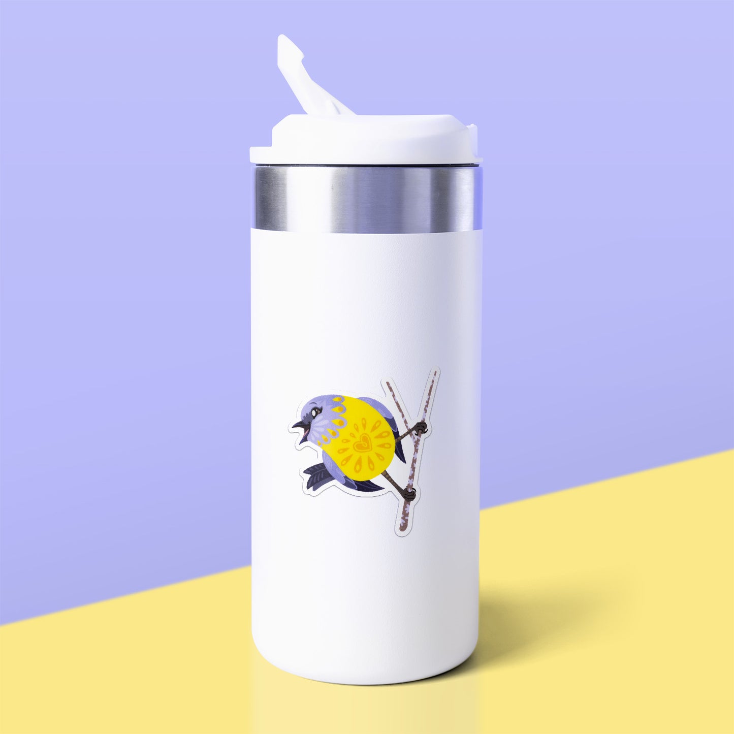 Colourful sticker of an eastern yellow robin perched on a lichen-covered branch stuck to a white metal drink bottle on a yellow table on a lilac background.