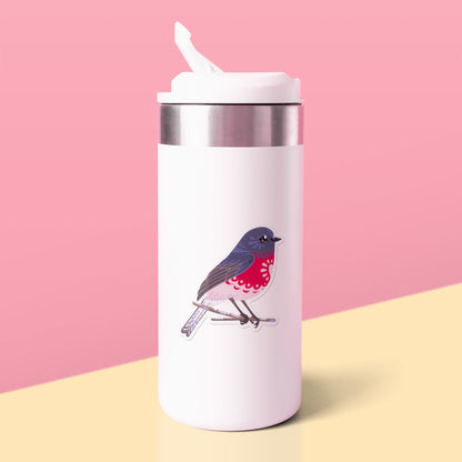 Colourful sticker of a male rose robin perched on a lichen-covered branch stuck to a white metal drink bottle on a yellow table on a pink background.