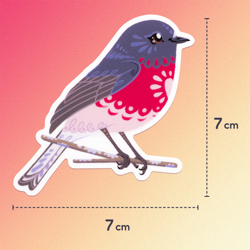 7x7cm colourful sticker of a male rose robin perched on a lichen-covered branch on a pink, coral and cream gradient background.