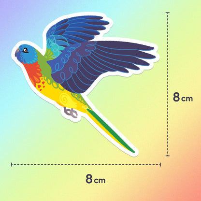 8x8cm colourful sticker of a Scarlet-Chested Parrot in flight on a rainbow gradient background.