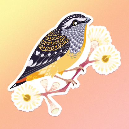 A colourful sticker of a spotted pardalote on a pink gum branch with pale yellow flowers on a yellow, orange and pink gradient background.
