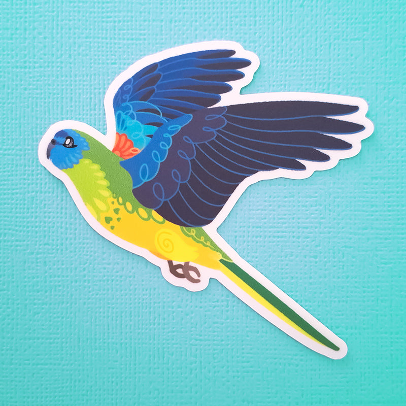 Real photo of a colourful sticker of a Turquoise Parrot in flight on a blue-green canvas texture background.