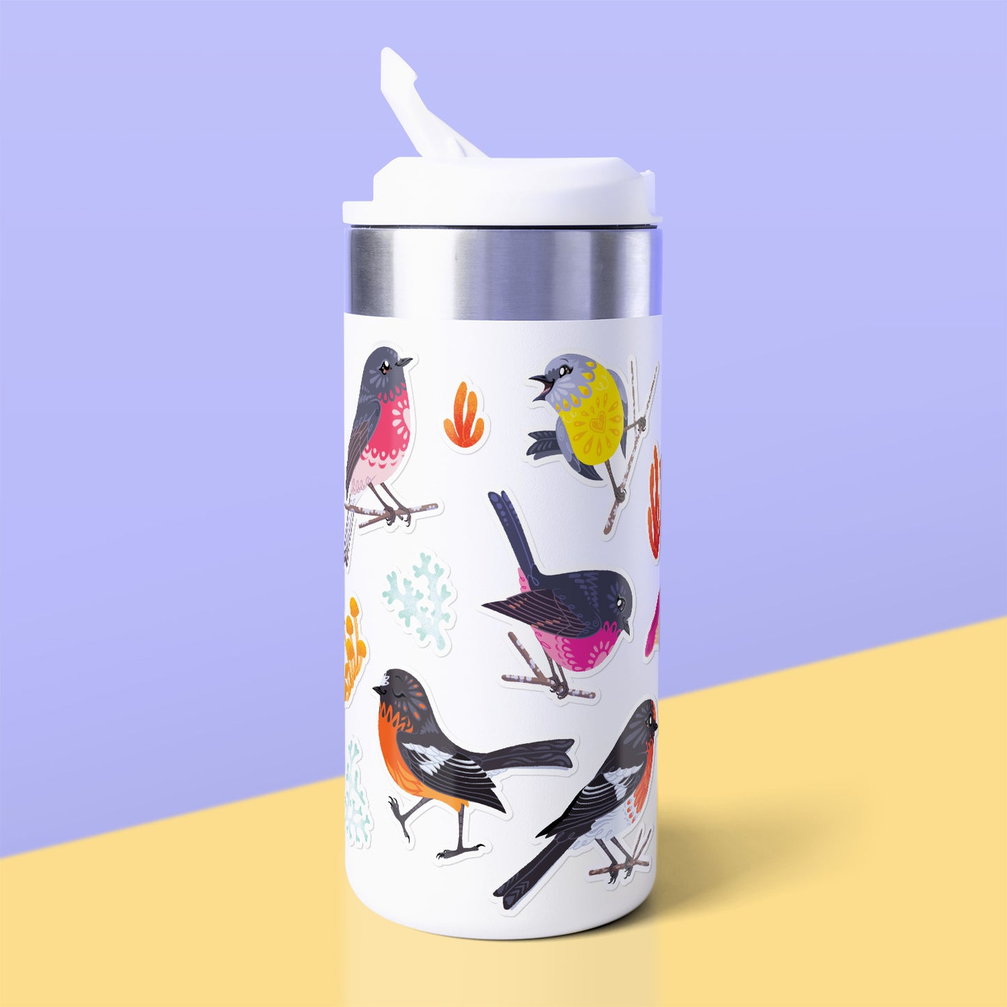 Assorted colourful red/pink/orange/black Australian robin, lichen and fungi stickers stuck to a white metal drink bottle on a yellow table on a lilac background.
