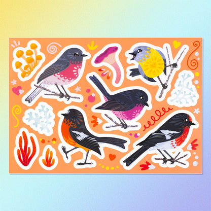 11 colourful red/pink/orange/black Australian robin, lichen and fungi stickers on a sheet on a yellow, blue and purple gradient background.