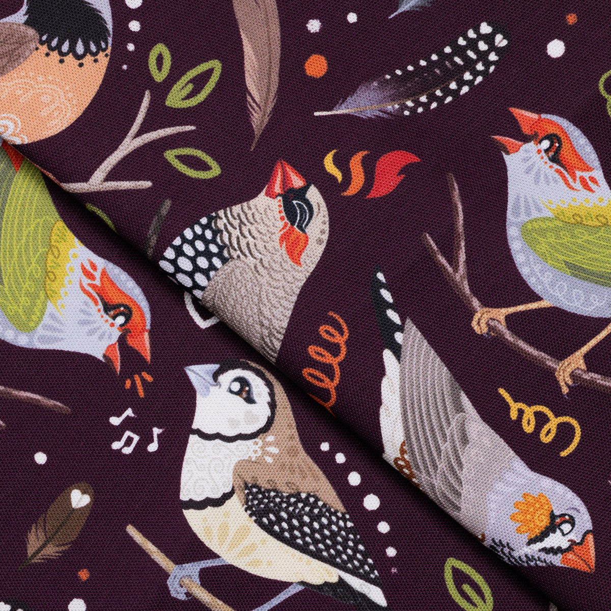 Closeup of a folded tea towel with a burgundy Australian finches pattern.