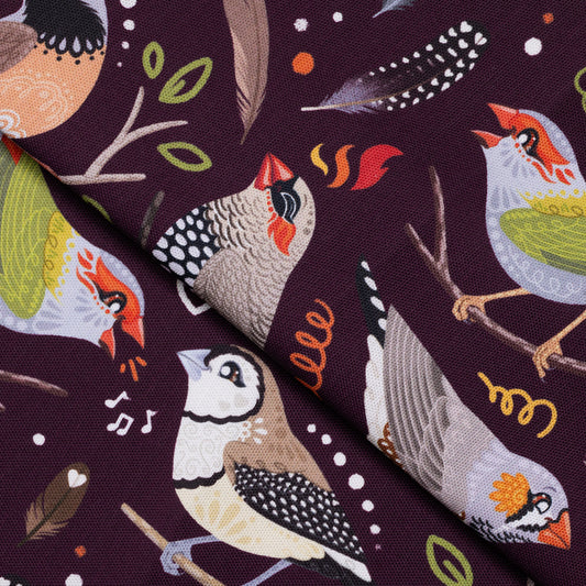 Closeup of a folded tea towel with a burgundy Australian finches pattern.