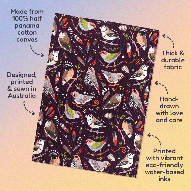 Features & benefits ('Made from 100% half panama cotton canvas, designed, printed & sewn in Australia, thick & durable fabric, hand-drawn with love and care, printed with vibrant eco-friendly water-based inks) surrounding a tea towel with a burgundy Australian finches pattern sitting flat on a pastel blue, orange and yellow background.