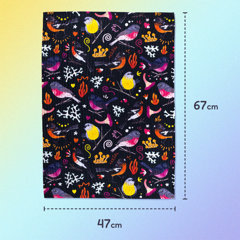 47x67cm tea towel with a black, pink, orange and yellow Australian robins pattern sitting flat on a pastel yellow and lilac background.