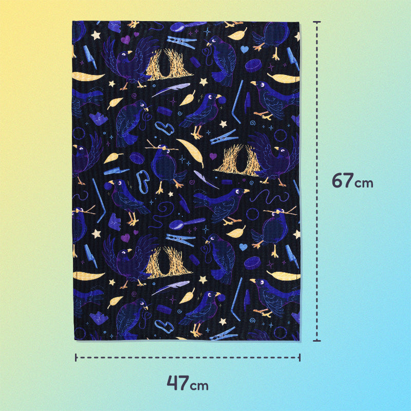 47x67cm tea towel with a black, blue, purple and yellow satin bowerbirds pattern sitting flat on a pastel yellow and blue background.