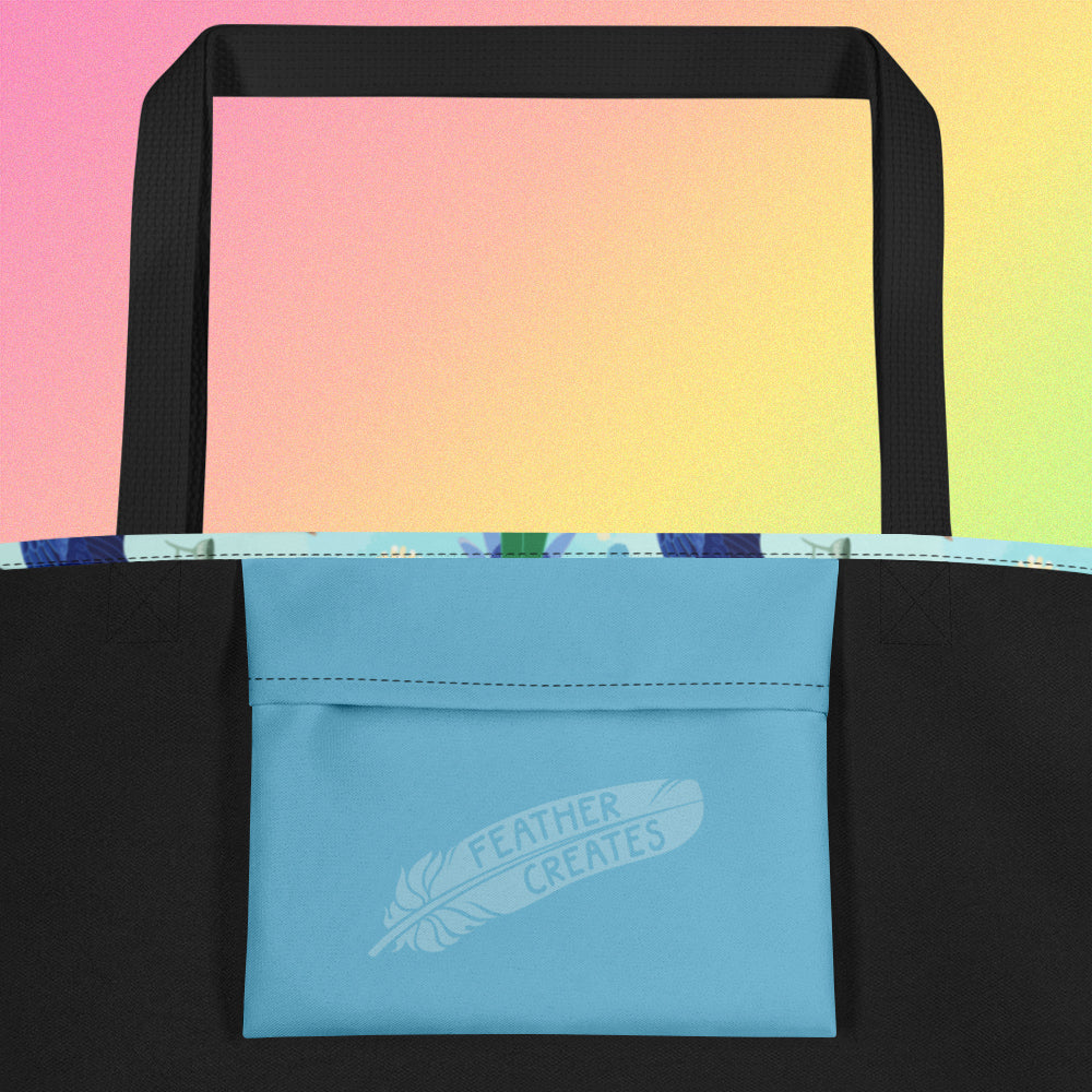 Close up of a blue fold-over pocket on the inside of a tote bag with a black strap on a gradient pink, yellow and green background.