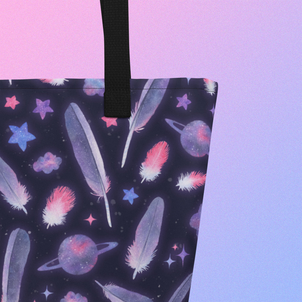 Close up of a tote bag with a black strap and galah cockatoo feather and galaxy-themed pattern on a gradient purple background
