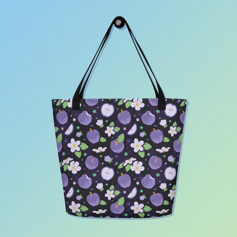 Tote bag with a black strap and purple apple and flower pattern on a gradient blue and green background