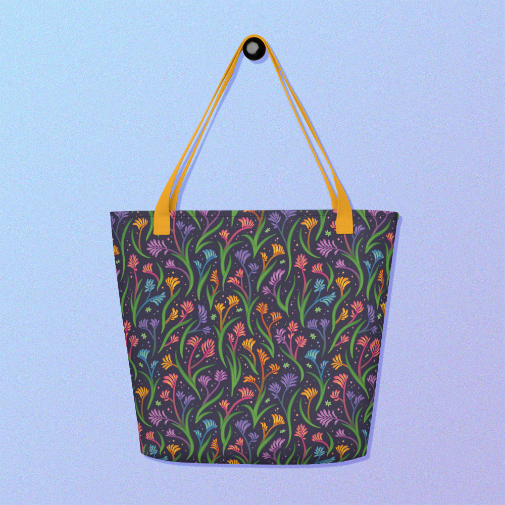 Tote bag with a yellow strap and a floral rainbow kangaroo paw pattern on a gradient blue and purple background.