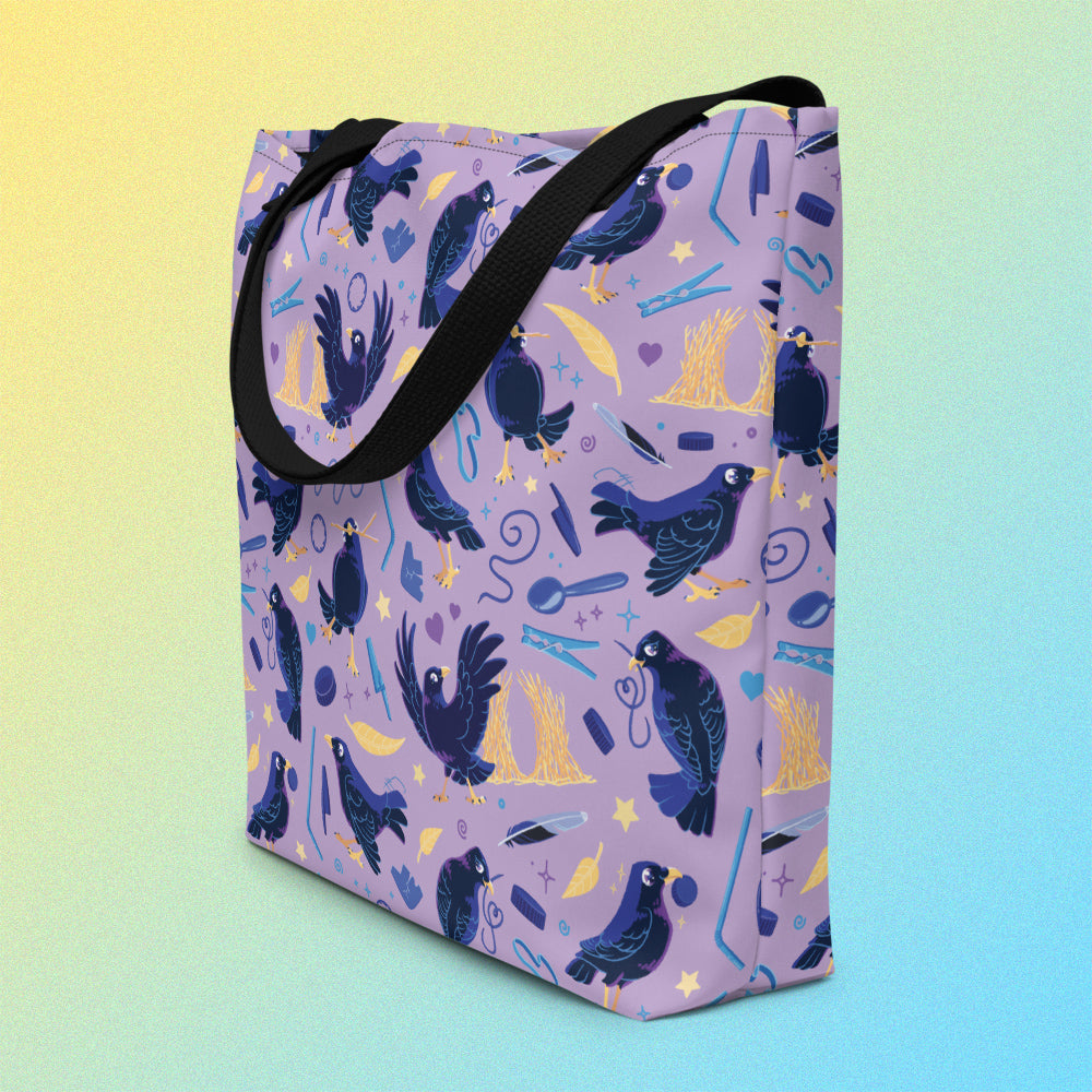 Tote bag on an angle with black handles and a purple/blue/yellow satin bowerbird pattern on a yellow and blue gradient background.