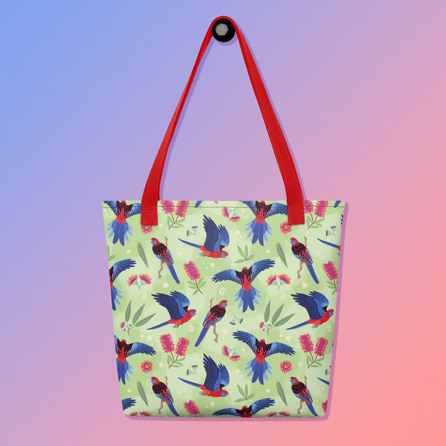 Tote bag with red handles and a crimson rosella parrot pattern on a gradient purple and pink background