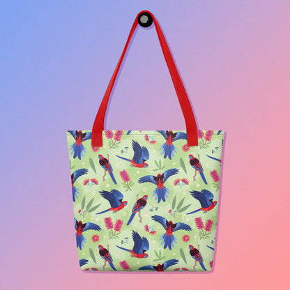 Tote bag with red handles and a crimson rosella parrot pattern on a gradient purple and pink background