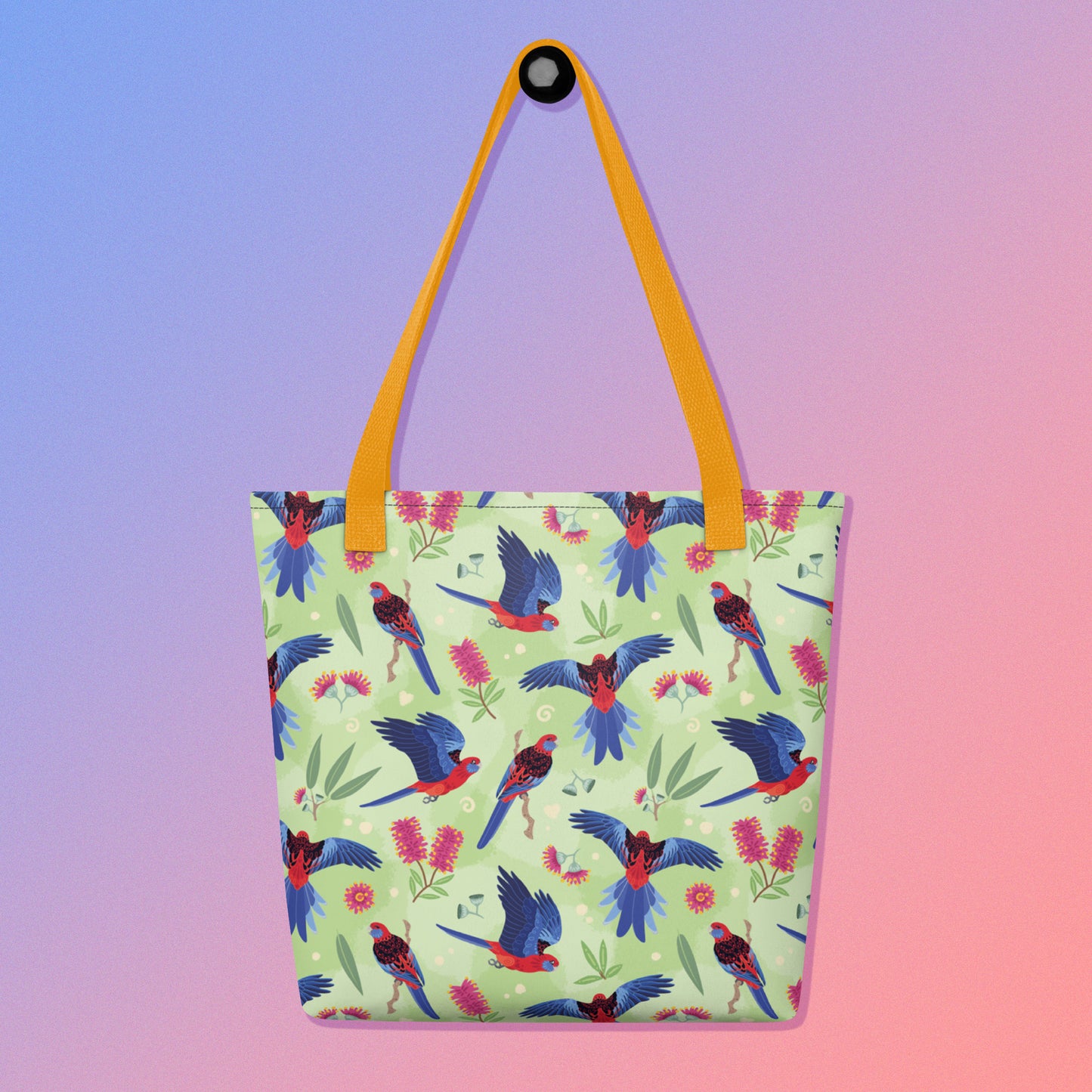 Tote bag with yellow handles and a crimson rosella parrot pattern on a gradient purple and pink background