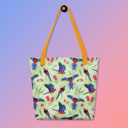 Tote bag with yellow handles and a crimson rosella parrot pattern on a gradient purple and pink background