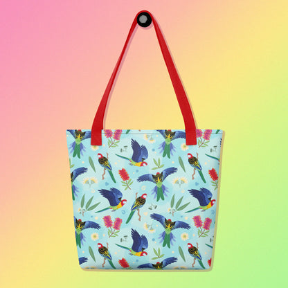 Tote bag with red handles and an eastern rosella parrot pattern on a gradient pink, yellow and green background