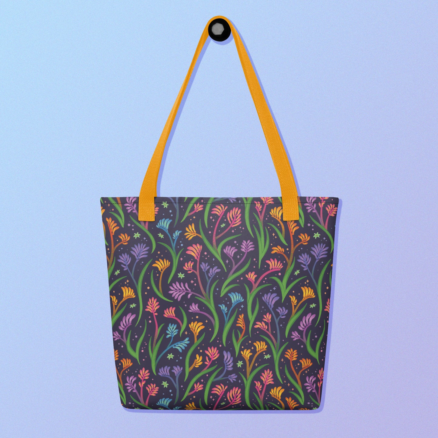 Tote bag with a yellow strap and a floral rainbow kangaroo paw pattern on a gradient blue and purple background.