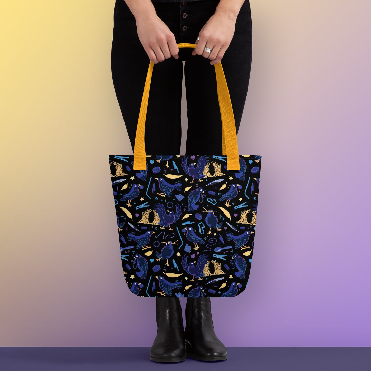 Person holding a tote bag with yellow handles and a black/blue/yellow satin bowerbird pattern pattern on a yellow and purple gradient background