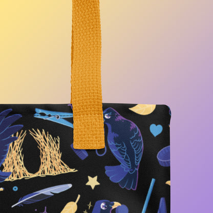 Close up of a tote bag with yellow handles and a black/blue/yellow satin bowerbird pattern pattern on a yellow and purple gradient background