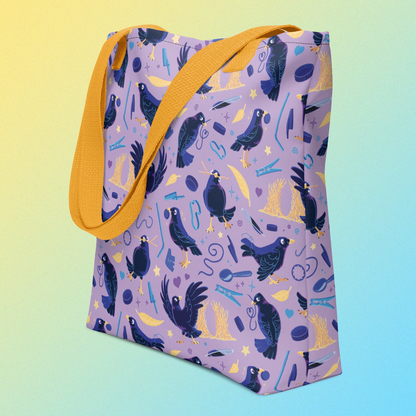 Tote bag with yellow handles and a purple/blue/yellow satin bowerbird pattern on an angle on a yellow and blue gradient background