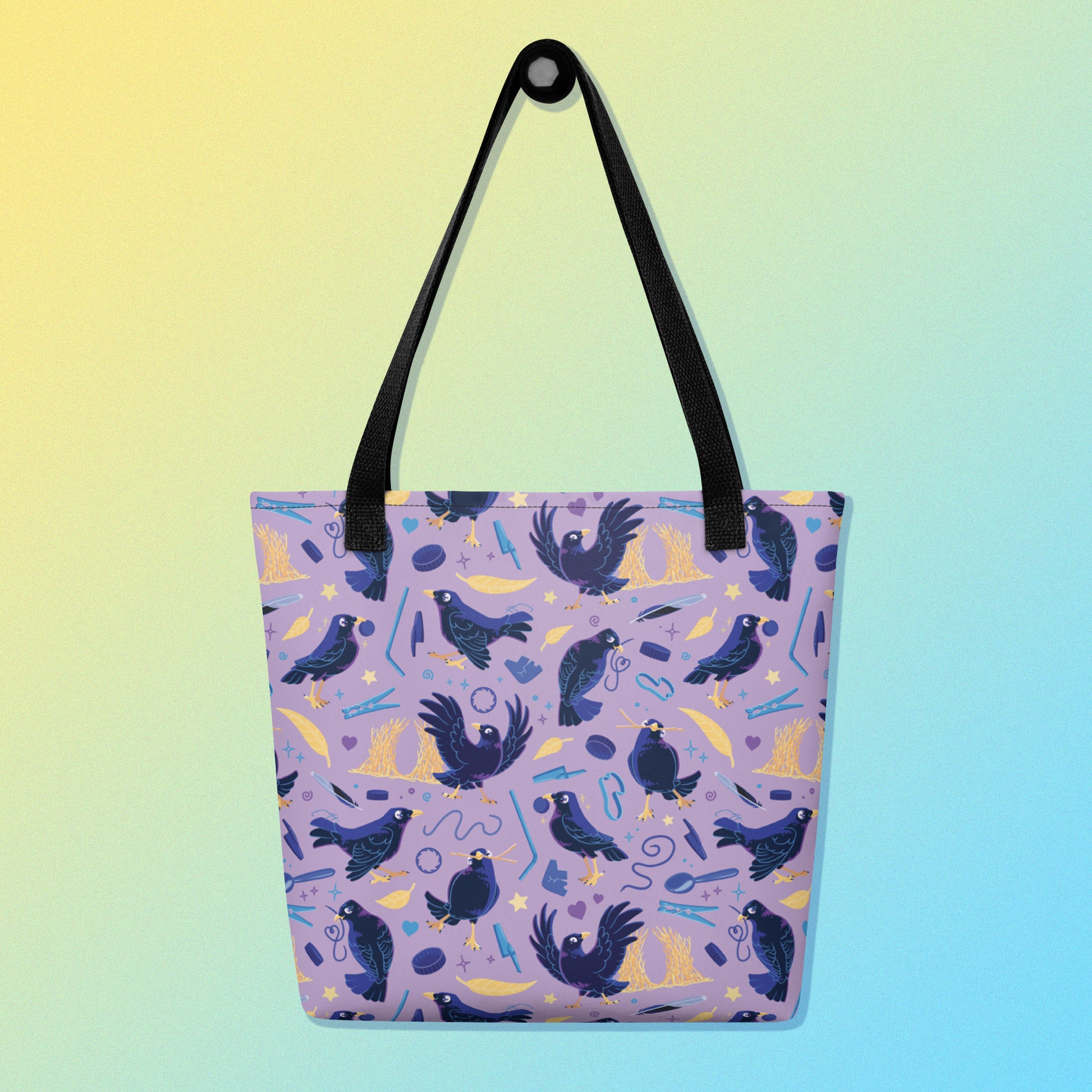 Tote bag with black handles and a purple/blue/yellow satin bowerbird pattern on a yellow and blue gradient background